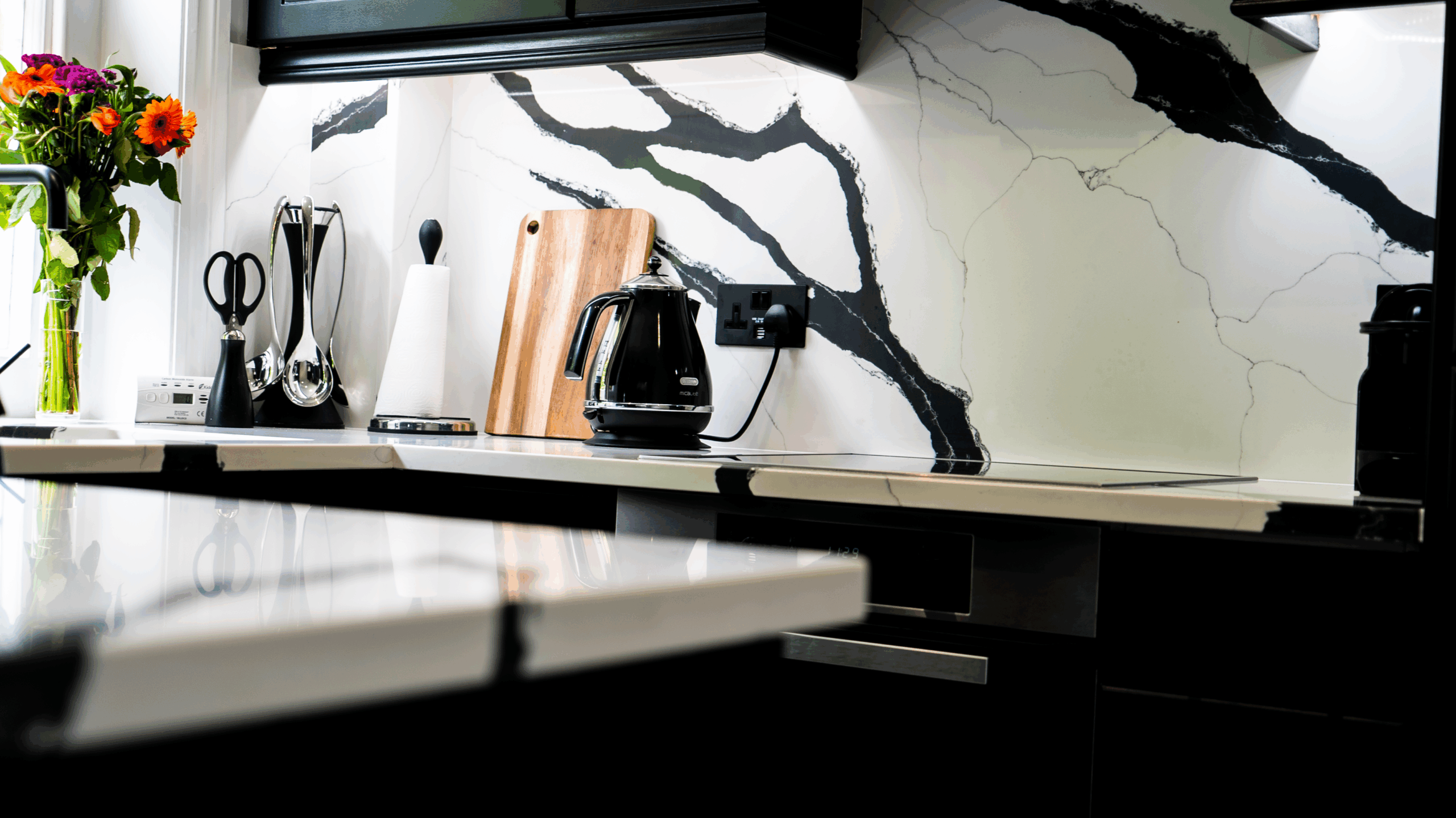 Black Calacatta Quartz splashback detail with bold black veining behind the worktop and appliance area