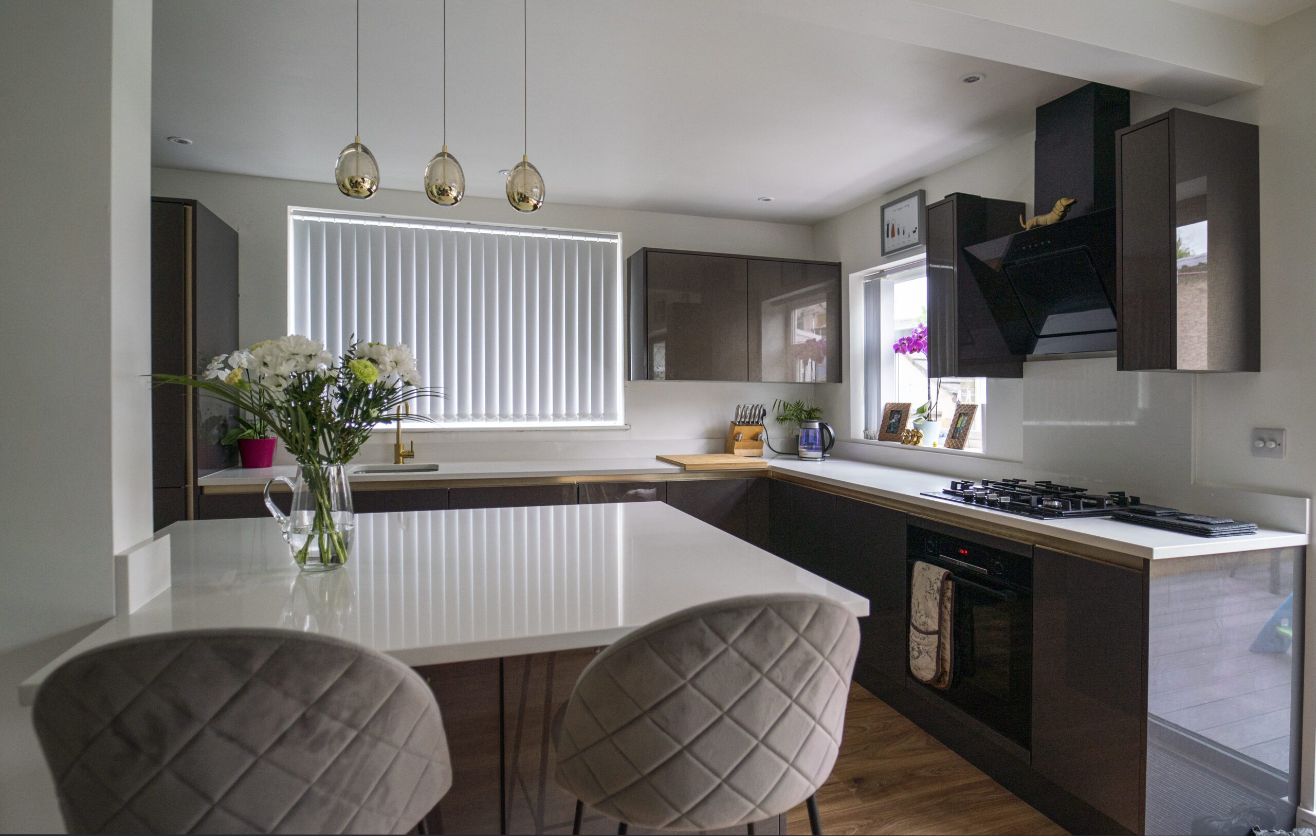 Wide view of a modern kitchen with Imperial White Quartz worktops on the perimeter and island