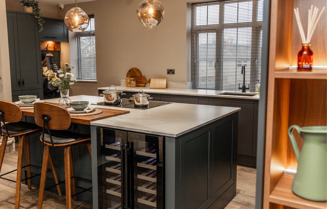 Volakas White Porcelain island worktop installed on dark cabinetry, shown in a modern kitchen with bar seating.
