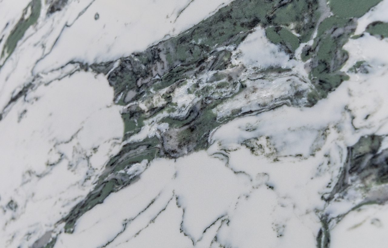 Emerald Calacatta Quartz pattern close-up showing dense green mineral-style movement through a white surface