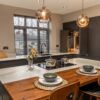 Volakas White Porcelain island worktop with subtle grey veining, shown with pendant lighting and dining place settings.