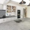 Grey Concrete Quartz worktop with double bowl sink cut-out and chrome tap in a bright modern kitchen