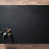 Overhead view of a honed Absolute Black Granite worktop showing a matte black surface, photographed from above with a small styled tray in the corner.