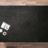 Overhead view of a Black Pearl Granite worktop showing the dark flecked pattern, photographed from above with a small styled tray in the corner.