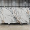 Calacatta Gold Borgnini Porcelain full slab on a display stand, showing a white marble effect background with grey veining and gold accents