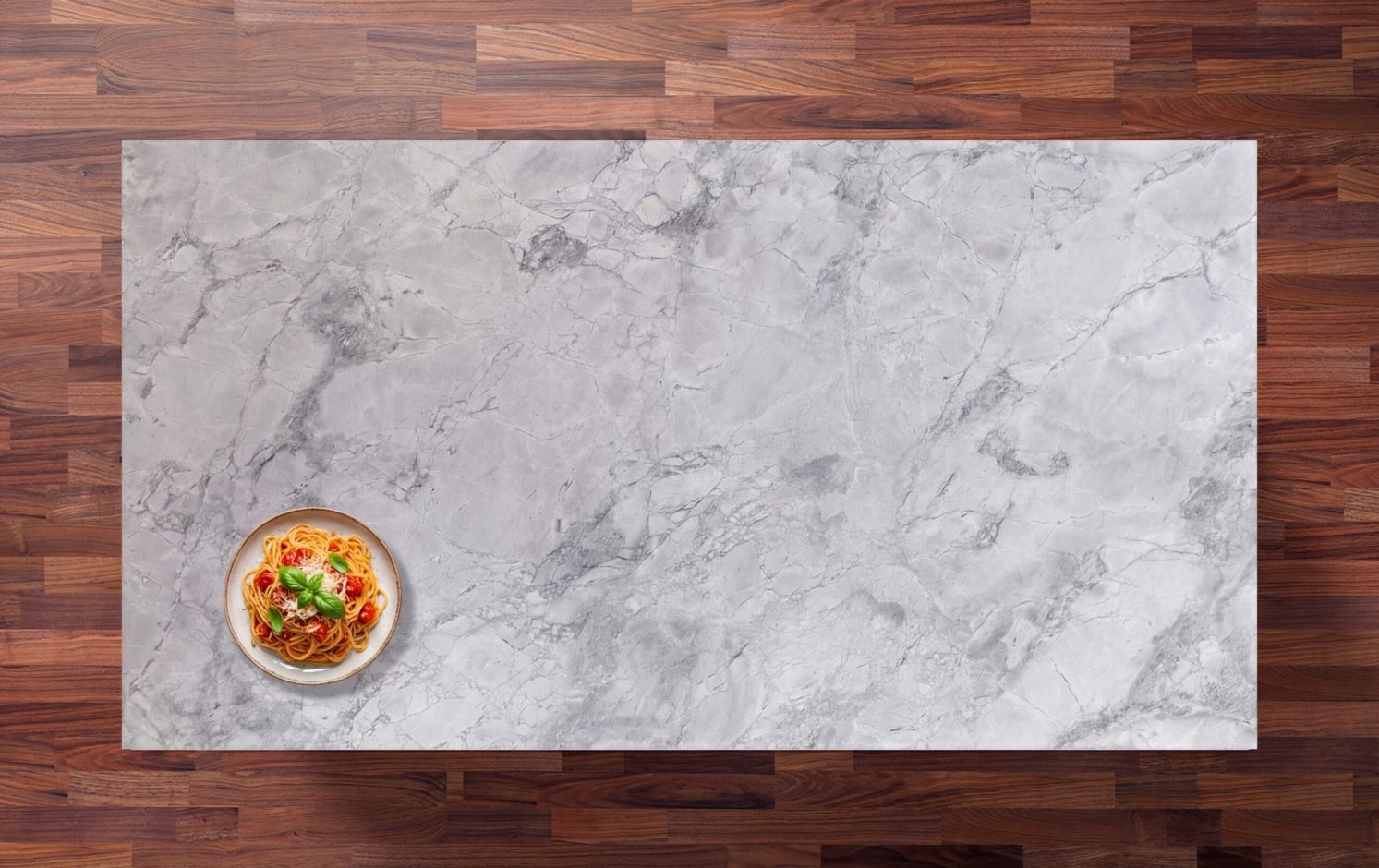 Overhead view of a Bianco Eclipsia Granite worktop showing soft pale grey movement and clouding, photographed from above with a small styled tray in the corner.