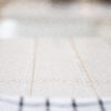 Low-angle close-up of Ice White Quartz drainer grooves showing the clean channel lines across the surface
