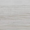 Close up slab photo of Bianco Macaubas Granite showing fine linear grey veining running horizontally across a pale stone surface.
