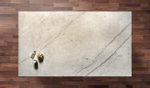 Overhead view of an Ivory Spice Granite worktop showing warm cream tones and soft natural veining, photographed from above with a small styled tray in the corner.