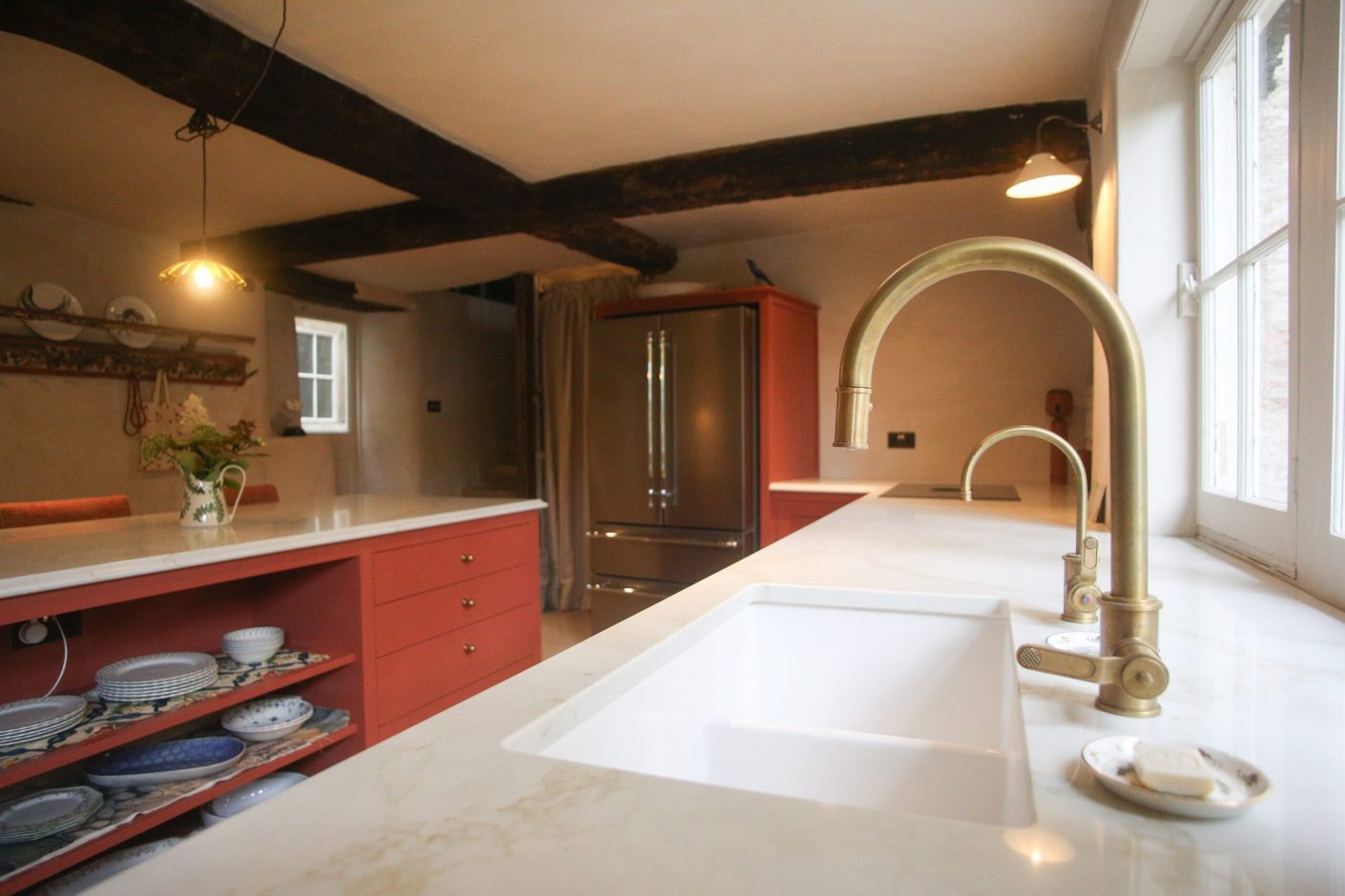 Supreme Calacatta Quartz worktop run with double bowl sink and brass taps in a traditional kitchen setting