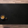 Overhead view of a Nero Cosmos Granite worktop showing a deep black surface with subtle sparkling flecks, photographed from above with a small styled tray in the corner.