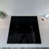 White Starlight Quartz worktops with black induction hob set into the surface in a modern kitchen