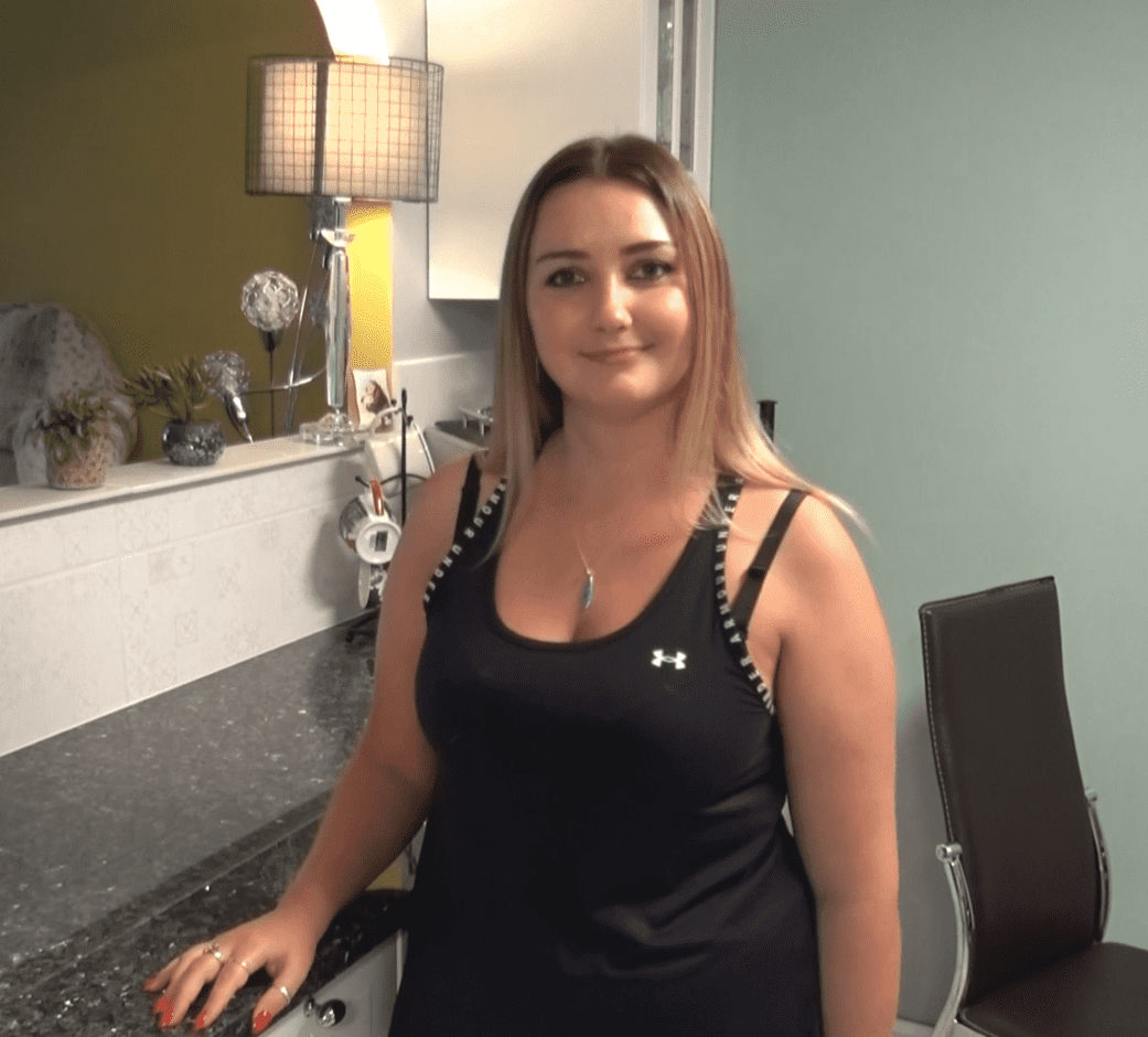 Testimonial video still of a customer standing in their kitchen after a Blue Pearl Granite worktop installation by Mayfair Worktops.