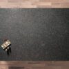 Overhead view of a Steel Grey leather Granite worktop showing fine speckling and a textured finish, photographed from above with a small styled tray in the corner.
