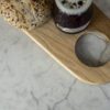 Super White Quartz worktop close-up with soft grey veining beside a wooden serving board and breakfast items