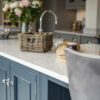 Super White Quartz worktop edge detail on blue cabinetry showing a smooth stone-effect surface beside the sink area