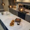 Large Super White Quartz island worktop with curved edge and light marble-effect veining in a modern kitchen