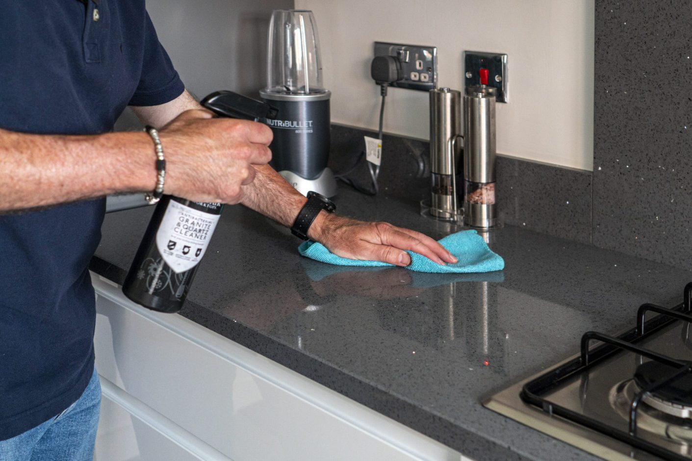 Grey Starlight Quartz worktop being wiped clean showing the smooth speckled surface finish