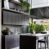 Kelya Porcelain worktops in deep charcoal with white veining in a modern kitchen with island and plants