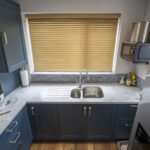Overhead view of Arabescato Quartz worktops around a double sink in a kitchen with dark cabinets