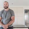 Testimonial video still of a customer speaking in their kitchen after a Cosmic Black Granite worktop installation by Mayfair Worktops.