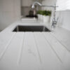 Statuario Bianco Porcelain drainer grooves beside sink showing subtle grey veining