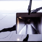 Black Calacatta Quartz worktop with inset sink shown in close-up with bold veining and polished white surface