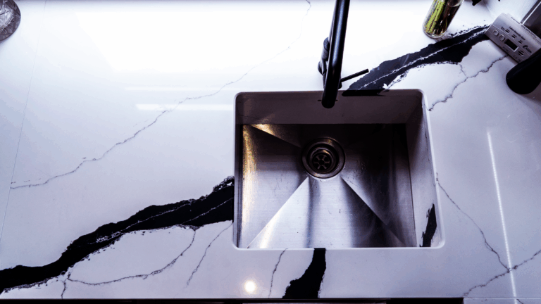 Black Calacatta Quartz worktop with inset sink shown in close-up with bold veining and polished white surface