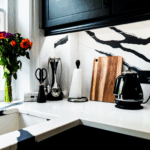 Black Calacatta Quartz corner worktop with matching splashback showing bold veining behind kitchen appliances