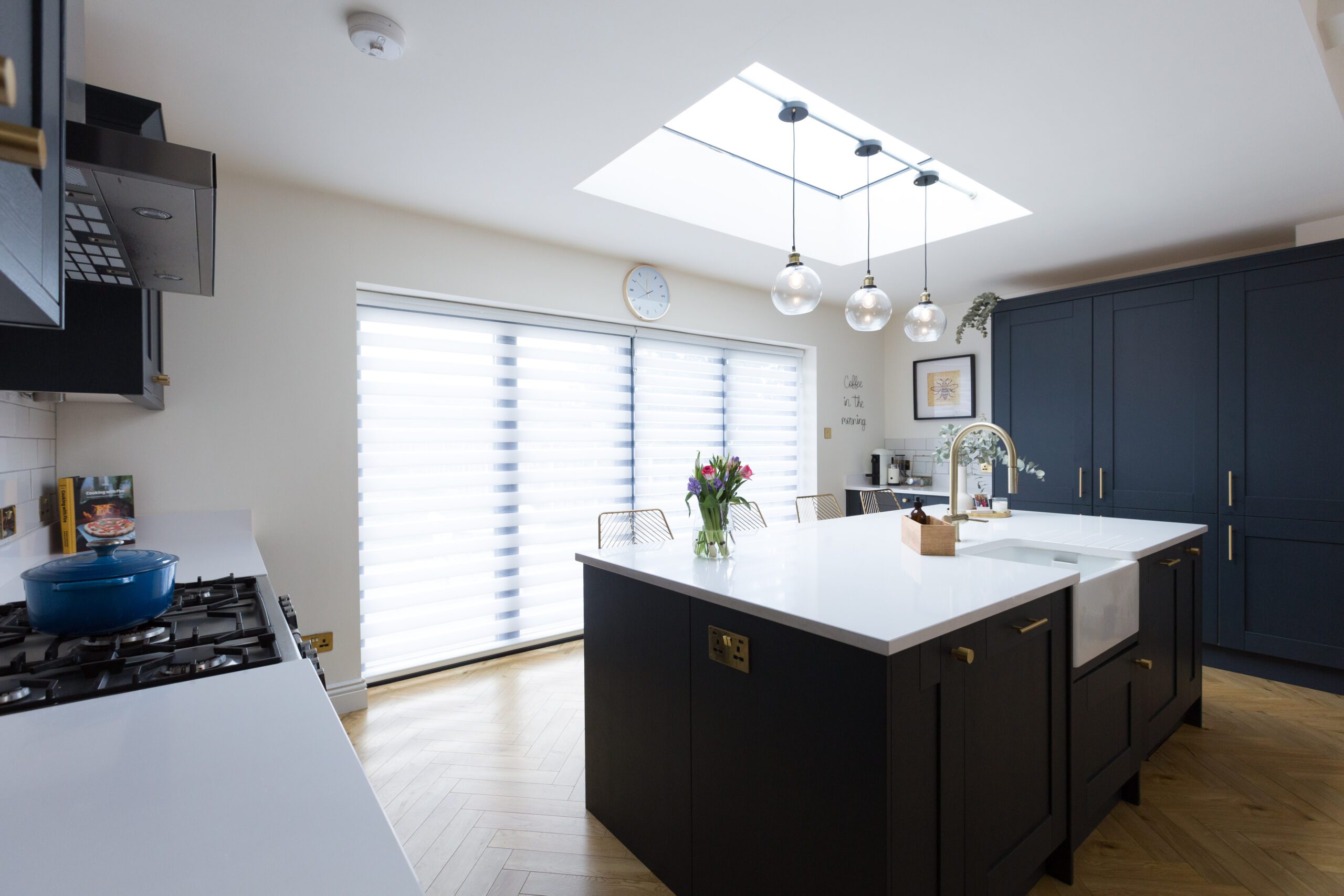 Blanco Zeus Quartz island worktop in an open-plan kitchen with bright white surface and pendant lights above