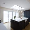 Blanco Zeus Quartz island worktop in an open-plan kitchen with bright white surface and pendant lights above