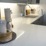 Close up view of Aspen Shimmer Quartz worktops beside the sink with soft lighting