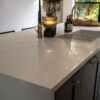 Close-up of Olympus White Quartz worktop edge with subtle grey veining and a polished finish