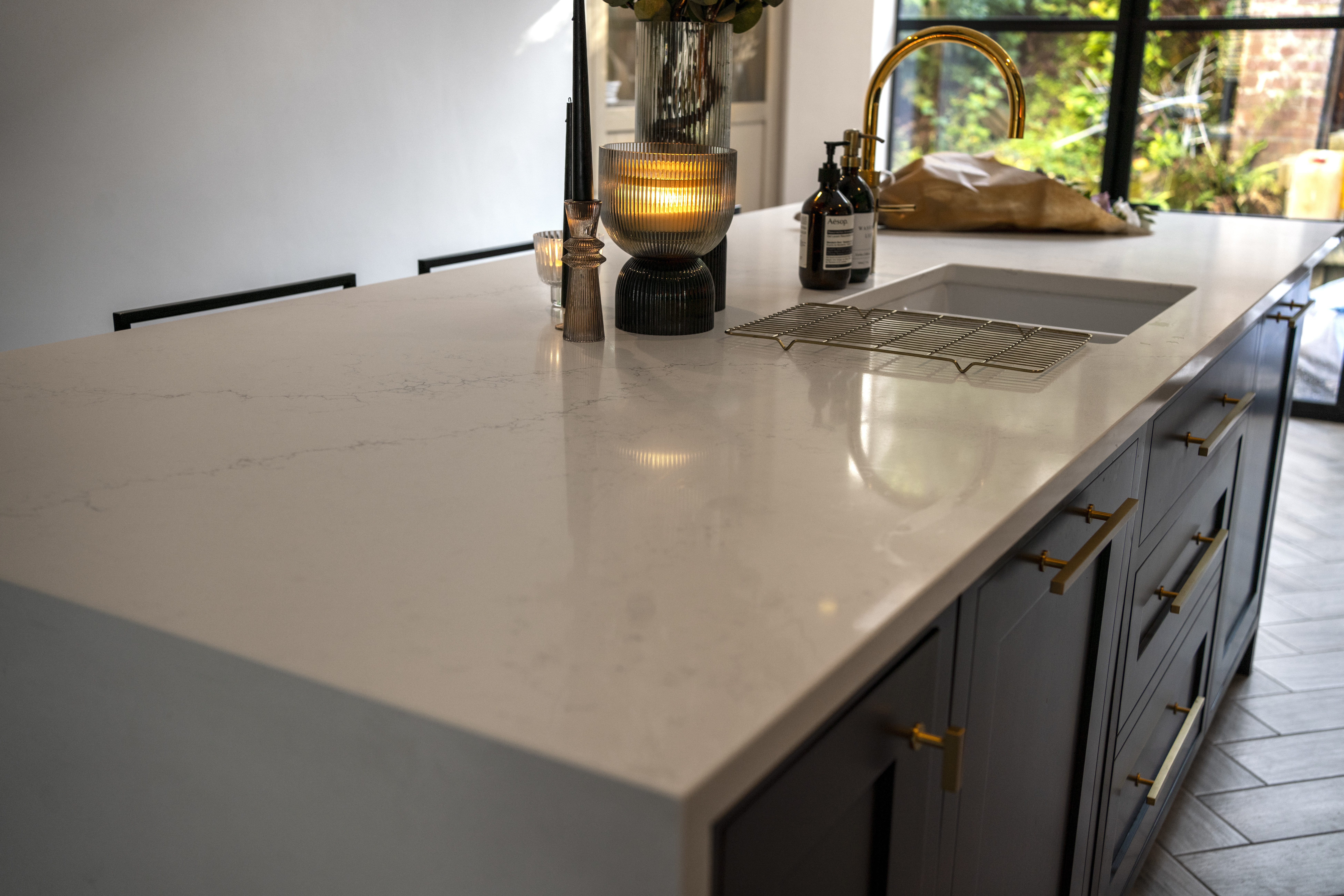 Close-up of Olympus White Quartz worktop edge with subtle grey veining and a polished finish