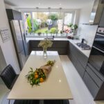 Blanco Zeus Quartz island worktop shown from above with a bright white surface and dining setup in a modern kitchen