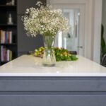 Blanco Zeus Quartz island worktop with bright white surface shown end-on with flowers on the countertop