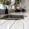 Blanco Zeus Quartz worktop close-up with integrated drainer grooves beside an undermount sink on a bright white surface