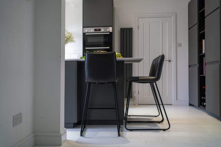 Open-plan kitchen view with Blanco Zeus Quartz island worktop and bar seating shown from a side angle