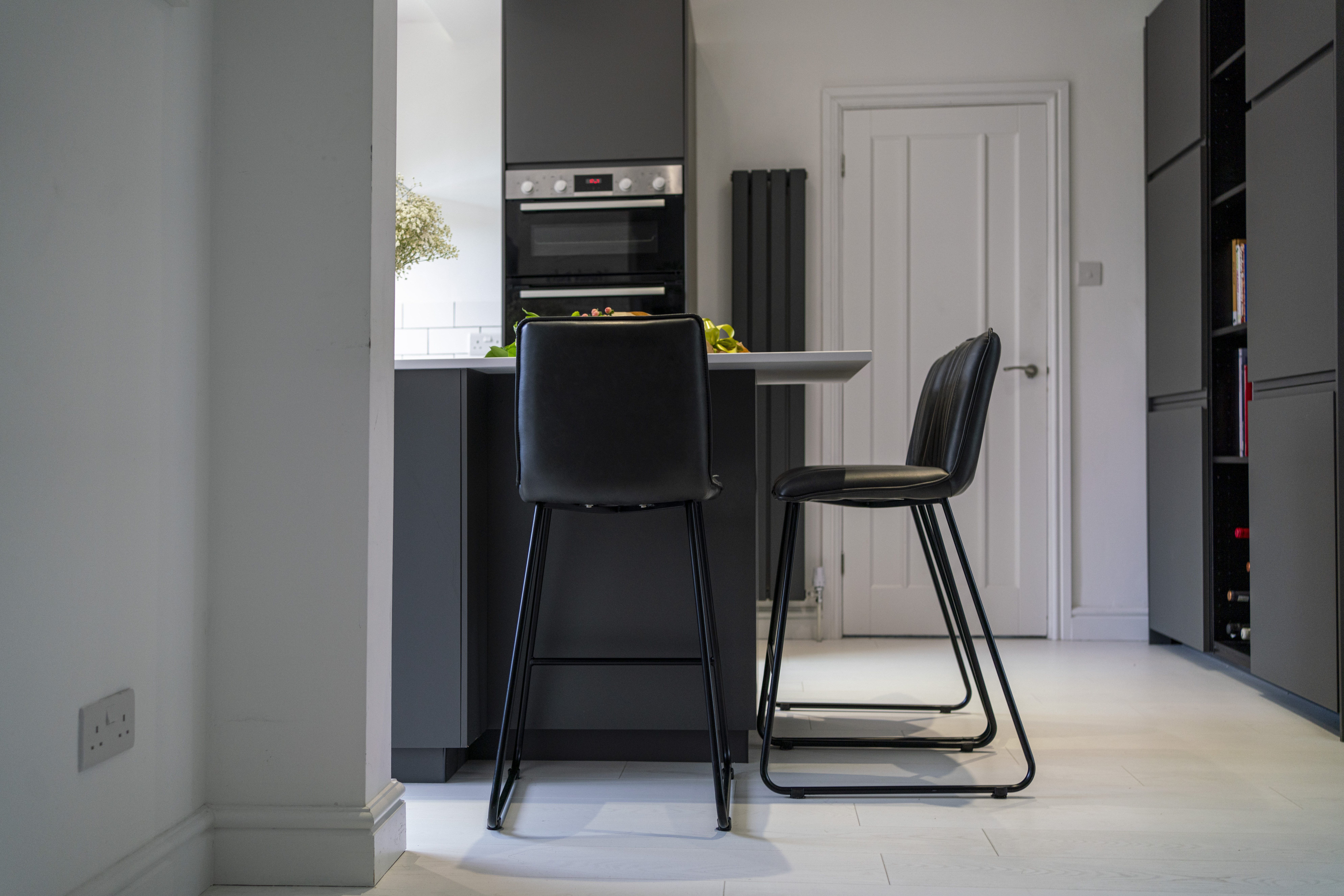 Open-plan kitchen view with Blanco Zeus Quartz island worktop and bar seating shown from a side angle