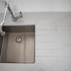 Top down view of Statuario Bianco Porcelain worktops with stainless steel sink and subtle grey veining
