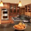 Traditional kitchen view with Nero Impala Granite worktops on the island and perimeter run, showing the dark speckled Granite surface with wood cabinetry and pendant lights.