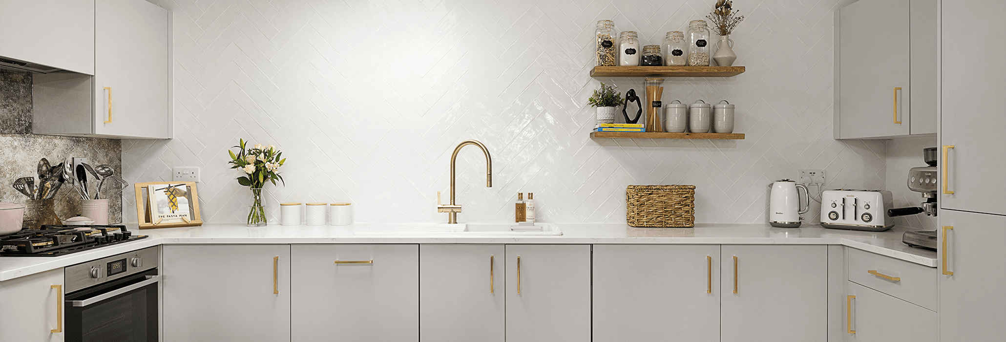 Modern kitchen fitted with Carrara Quartz worktops and brass accents