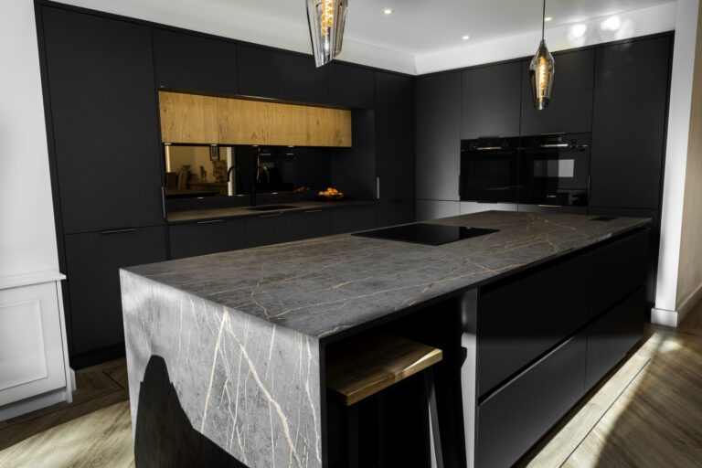 Laurent Porcelain waterfall island worktop with a draped cloth and bar stools, in a modern grey kitchen setting.