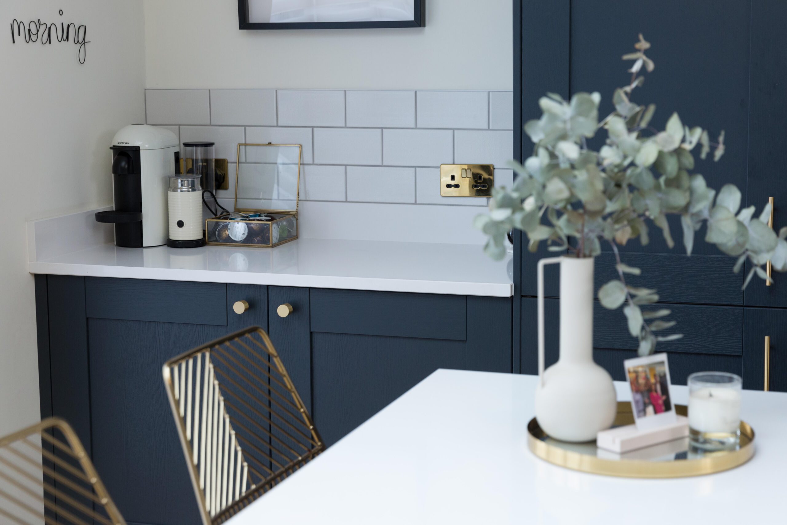 Blanco Zeus Quartz worktops on a kitchen run with bright white surface against blue cabinets and tiled splashback