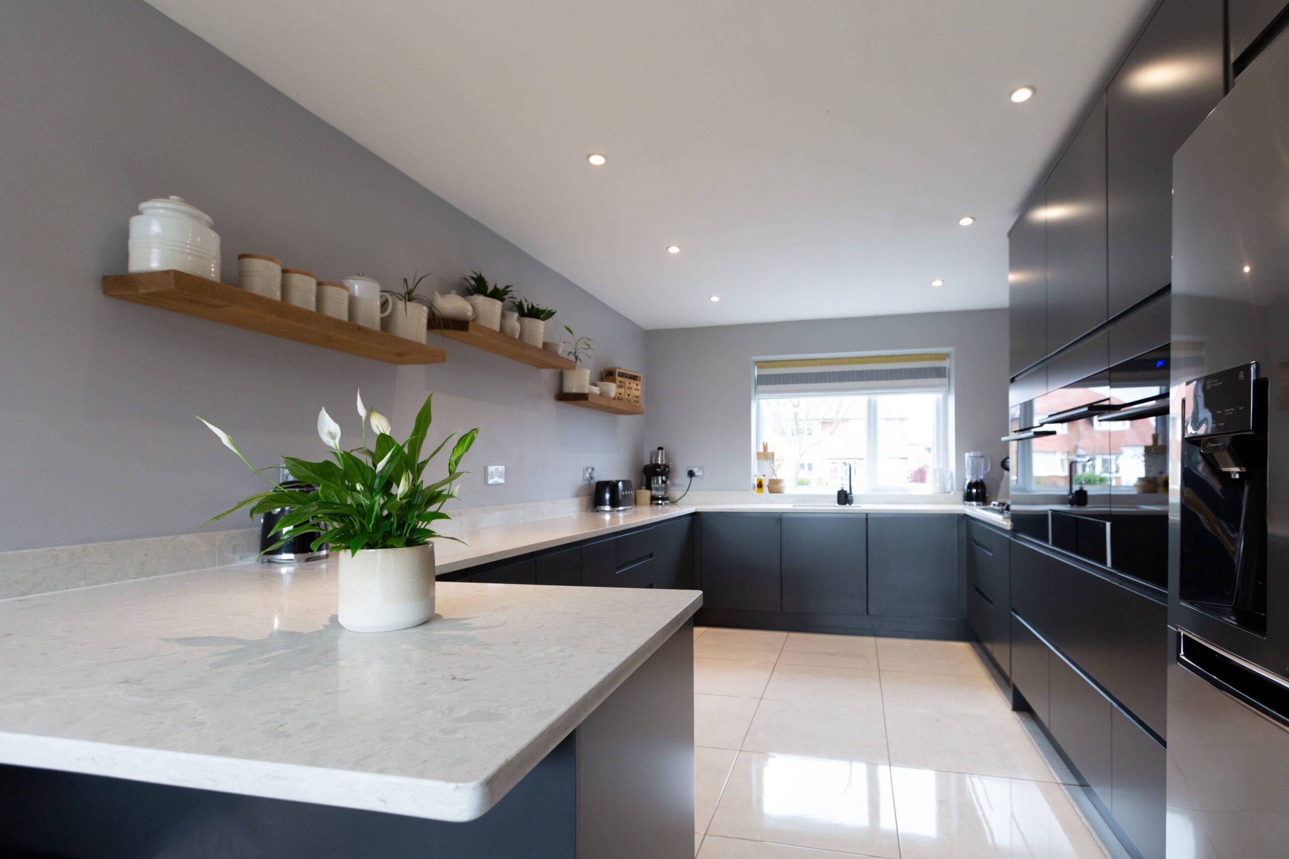 Grey Drift Quartz peninsula worktop with clean edge detail and pale stone-effect pattern in a modern kitchen